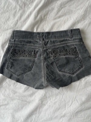 Grå jeansshorts  - Supercoola jeansshorts i ett ganska tunt jeanstyg. Coola detaljer på fickorna. De har fyra knappar framtill och är väldigt lågmidjade. Sparsamt använda. Stl XS. 💕