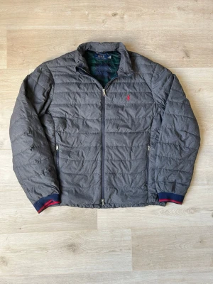 Grå Ralph Lauren Lätt Dunjacka Storlek XXL - Fin RL vårjacka i grå färg. Jackan är i mycket bra skick och sparsamt använd. |  Äkta som allt annat jag säljer! ✅ |  Storlek: XXL | Skick: Mycket Bra Skick | Färg: Grå | Märke: Ralph Lauren | Modell: Jacka |  Hör gärna av dig vid frågor så svarar jag så fort jag kan! 😁|    (SKU - 82)