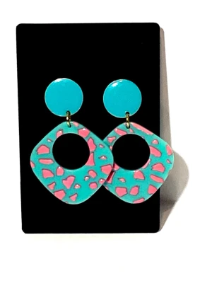 Mönstrade örhängen i turkos och rosa  - Färgglada örhängen i akryl  med rund turkos platta upptill och stora, fyrkantiga hängen i turkost med rosa leopardmönster. Örhänget rund platt enamel pläderad i metall . Längd 5.5cm bredd länk /3.5 cm örhänget / 16mm