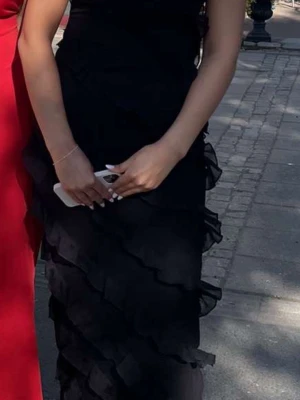 Svart långklänning med volanger - Svart långklänning med tunna axelband och v-ringad hals. Klänningen har flera lager av volanger som ger en snygg och flowy look. Perfekt för dig som vill ha en elegant och trendig stil. Materialet känns lätt och luftigt. Använd en gång! Prefekt till bal osv🥰 Skriv gärna om frågor!💕🙌🏼🙌🏼