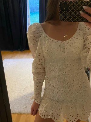 Vit klänning - Supersöt vit kort klänning med lite puffärmar. Klänningen har en figurnära passform, volangkant nertill och broderade hålmönster över hela tyget. Perfekt för sommaren och studenten. Klänningen är i storlek 38 men liten i storleken och passar mig som är 34