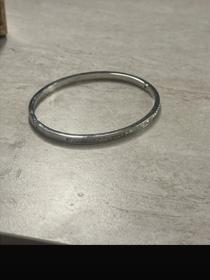 Silverfärgat armband - Snyggt stelt armband i silverfärg med en slät, minimalistisk design. Armbandet har en rund form och är tillverkat i metall. Perfekt för dig som gillar stilrena accessoarer som passar till allt.