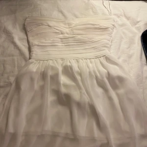Vit axelbandslös klänning från Three Little Words - Säljer en superfin vit axelbandslös klänning från Three Little Words. Inbyggd bh finns i klänningen. Perfekt för sommarens fester eller studentfiranden! 🌸storleken är oklart men runt S skulle jag säga!