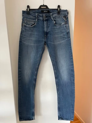 Blå jeans från Replay herr - Säljer ett par klassiska blå jeans från Replay med snygg tvätt och diskreta slitningar. Dom är i storlek W32 L34. Jeansen är tillverkade i bomull och har en bekväm passform som passar perfekt till en avslappnad stil. Lite tecken på användning