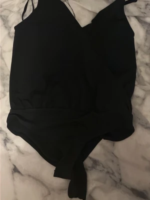 Svart body  - Söt svart omlott body, köpt från Sellpy för 55kr. Orginalmärke amisu. Har själv aldrig användt. Storlek xs💞