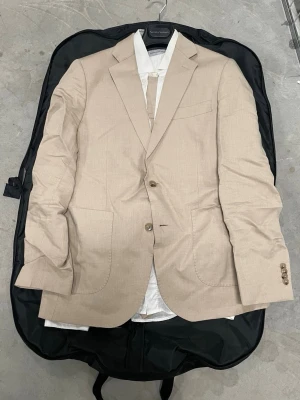 Skitsnygg Beige kostym - Skitsnygg beige kostym Den är endast använd två gånger, så den är i princip som ny. Förhoppningsvis får du mer användning för den än jag! :) Kavaj - 50 ———— byxor - 52