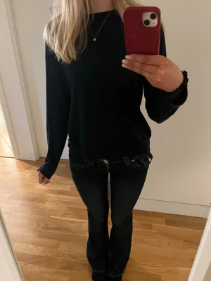 Svart basic långärmad tröja - En enkel och stilren väldigt mörkblå långärmad tröja med rund halsringning och även en slits på sidan. Perfekt att matcha med jeans eller kjol. Tröjan har en rak passform och är gjord i ett mjukt material som känns skönt mot huden.