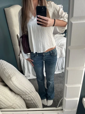 Blå bootcut jeans med låg midja - Säljer ett par klassiska blå bootcut jeans med låg midja och femficksmodell. Jeansen har fin fick design. Kontakta vid frågor💗