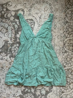 Turkos minidress - Söt turkos kortklänning med tunna ränder och volang nedtill. Klänningen har djup v-ringning och är ärmlös, perfekt för varma dagar. Tillverkad i ett mjukt bomullstyg som känns luftigt och bekvämt. KOLLA GÄRNA IN ALLT ANNAT JAG SÄLJER OCKSÅ🩷