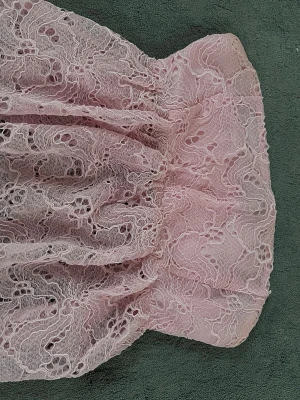 Rosa spetstopp axelbandslös - Söt axelbandslös top i ljusrosa spets med volangig kjol och fodrad insida. Toppen har ett romantiskt uttryck med detaljerad spets och passar perfekt för sommarens alla tillfällen.