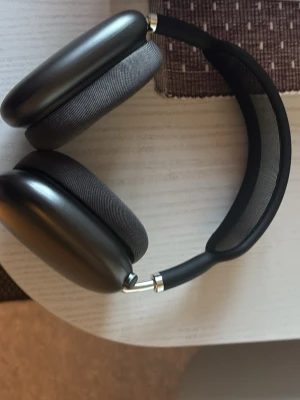 Apple AirPods Max svarta hörlurar - Snygga och moderna Apple AirPods Max i svart med mjuka öronkuddar i tyg och ett robust huvudband med mesh. Hörlurarna har en stilren design i aluminium och levereras med laddkabel. Perfekta för musik, gaming eller film.