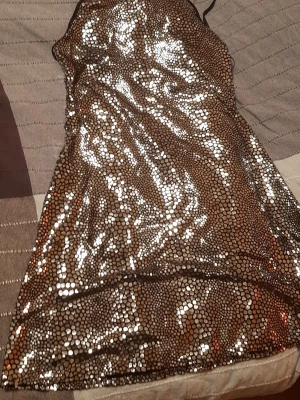 Glittrig paljettklänning Miss Selfridge - Supersnygg glittrig klänning från Miss Selfridge med tunna axelband och täckt av silvriga paljetter. Figurnära modell som verkligen fångar ljuset och ger en festlig look. Perfekt för dig som vill sticka ut och glänsa.