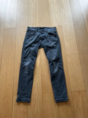 Replay - Snygga grå slim fit jeans från Replay med klassisk femficksdesign och dragkedjegylf. Jeansen har en modern tvätt och raka ben. Materialet är en mjuk bomullsblandning med lite stretch för extra komfort. Perfekta för en avslappnad och trendig look.