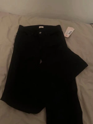 Svarta bootcut jeans från Nelly  - Svarta bootcut,low waist jeans från Nelly. Storlek 36, helt oanvända med prislapp. 