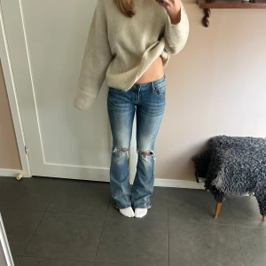 Blå bootcut jeans - Säljer dessa blå bootcut jeans med hål. Väldigt fint skick trots att de är använda ett par gånger! En hälla har gått av, men väldigt lätt att sy på igen (se bild 4). Skriv vid frågor eller fler bilder🥰