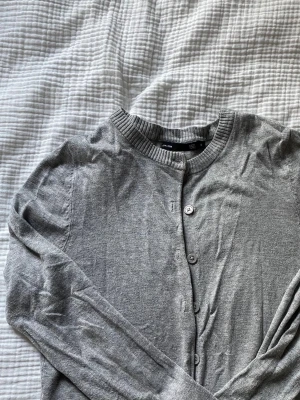 grå kofta  - En stilren grå kofta från lager 157 med rund halsringning och knappar framtill. Inga defekter eller tecken på användning. 