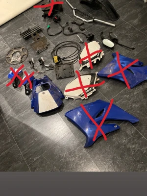 Styre moped  - Säljer ett gäng blåa och vita plastkåpor till moped, tillsammans med backspegel, blinkers, styre, bromsskiva och diverse smådelar. Perfekt för dig som vill fixa eller styla din moppe. Flera delar är märkta med rött kryss och ingår ej.