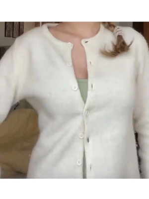 Vit kofta från Gina Tricot - Mysig vit kofta från Gina Tricot med fluffig textur och rund halsringning. Koftan har långa ärmar och knäpps framtill med små vita knappar