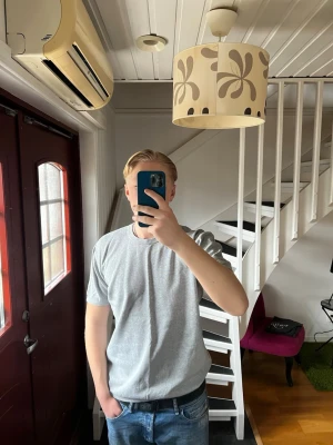 Grå  t-shirt från Kappahl  - Tröjan sitter tajt på armarna och pösigt vid magen och ryggen. Storlek M