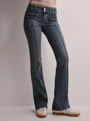 Blå bootcut jeans med fickdetaljer - Snygga blå bootcut jeans med markerade sömmar och dubbla fickor framtill. Jeansen har låg midja och klassisk femficksdesign. Perfekta för en trendig och avslappnad look. Uppsydda i längden passar 155-160