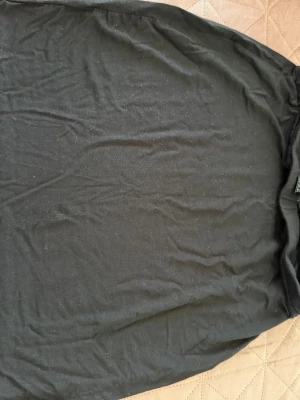 Svart basic t-shirt - En enkel svart t-shirt i klassisk modell med rund hals. T-shirten är tillverkad i mjukt bomullsmaterial och har korta ärmar. Perfekt för dig som gillar minimalistisk stil och vill ha ett plagg som funkar till många olika outfits.