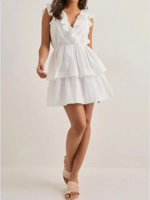 Nelly ”perfect frill dress” volangklänning med öppen rygg - Söt vit kortklänning med volangdetaljer, v-ringning och öppen rygg med knytband. Klänningen har dubbla lager i kjolen för extra volym och är ärmlös med fina volangkanter. Perfekt för sommarens alla tillfällen.