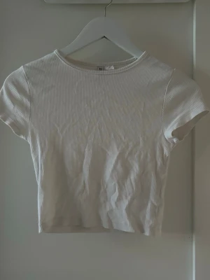 Vit t-shirt  - Vit t-shirt i storlek S, ribbat material. Använd ett antal gånger men hel och fin.