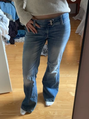 Vintage h&m jeans  - Säljer ett par blå bootcut jeans med snygg tvätt och dubbla knappar i midjan. Jeansen är lagade på baksidan vilket ger dom en cool look. 
