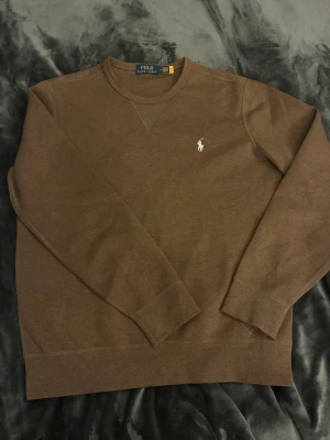 Polo Ralph Lauren tröja  - Oanvänd polo Ralph Lauren tröja i brun färg och storlek Medium. Säljer pga den används inte 🙂