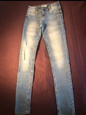 Cubus "Jegging Jane" – Ljusblå slitna jeans (S) - Säljer ett par snygga jeans från Cubus i modellen Jegging Jane. De har en klassisk ljusblå färg med snygga distressed-detaljer och slitningar framtill. Mått & Detaljer • Märke: Cubus • Modell: Jegging Jane • Storlek: Small (S) • Midjemått: Ca 34 cm mätt plant tvärsöver (omkrets ca 68 cm) • Innerbenslängd: Ca 76 cm (från skrevet och ner) • Material: 71% Bomull, 24% Polyester, 3% Viskos, 2% Elastan • Känsla: Något fastare denimkänsla än klassiska mjuka leggings.