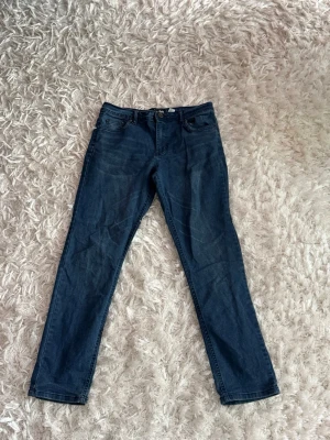 Mörkblå raka jeans - Snygga mörkblå jeans med rak passform och klassisk femficksdesign. Jeansen har normal midja och stängs med dragkedja och knapp. Perfekta till en avslappnad stil och funkar året runt. Materialet är klassisk denim i bomull.