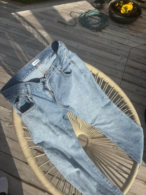 Ljusblå jeans från woodbird - Säljer ett par klassiska ljusblå jeans från Weekday med raka ben och femficksmodell. Jeansen har en snygg vintagekänsla och är tillverkade i bomull. Perfekta för dig som gillar en avslappnad och tidlös stil.