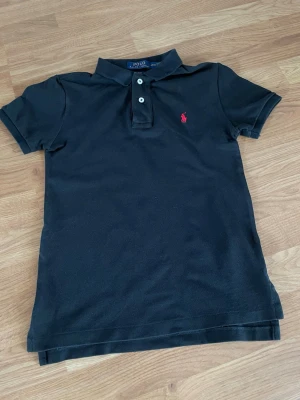 Svart piké  från Polo Ralph Lauren - Svart Ralph Lauren piké ,den ser grå ut på en av bilderna det blev något fel på kameran.