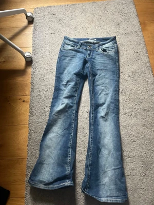 Blå bootcut jeans - Snygga blå bootcut jeans i strl XXS från GinaTricot, använda och har ett litet hål längs ner vid ena sömmen men annars är de i fint skick!💕