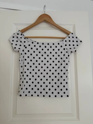 Vit prickig topp  - Supergullig topp med prickigt mönster ifrån New yorker, perfekt till sommaren🖤🤍  storlek L men skulle personliga säga att den lutar mer mot M. Kan bäras på och under axlarna, kontakta vid fler frågor eller bilder 🤍🖤