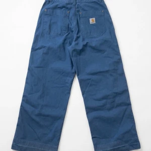 Blåa raka jeans från Carhartt - Säljer ett par blåa jeans från Carhartt med raka ben och klassiska bakfickor. Jeansen har en avslappnad passform och är tillverkade i ett slitstarkt bomullstyg. Perfekta för en chill och stilren look.