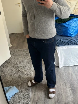 Grå stickad hoodie med dragkedja - Mysig grå stickad hoodie med dragkedja framtill och huva. Tröjan har ribbstickade muddar vid ärmslut och nederkant. Perfekt för lager-på-lager och chill dagar. Enkel och stilren design som passar till det mesta.