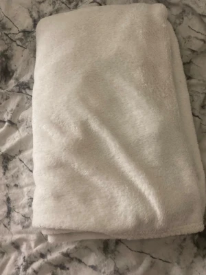 Mjuk vit fleecefilt - Supermjuk och fluffig vit fleecefilt, perfekt att mysa med i soffan eller använda som extra lager i sängen. Filten är enkel och stilren, tillverkad i ett lent och värmande fleecematerial.