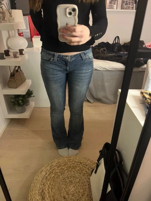Lågmidjade true religon jeans - Jättefina truereligon jeans med rosa detaljer på fickorna💞säljes endast för att de inte kommer till användning… enda defekten de har är lite lätt slitning längst nere, annars i väldigt fint skick
