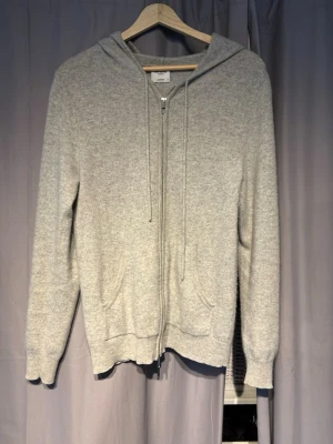 Ljusgrå zip-hoodie i Kashmir  - Säljer en ljus grå kashmir zip från John Henric. Knappt använda. Perfekt till sena sommarkvällar. Först till kvarn!