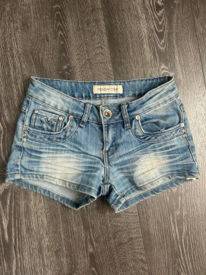 Lågmidjade jeansshorts - Snygga blå jeansshorts från MONDAY DENIM med låg midja och slitna detaljer framtill och baktill. Perfekta för varma dagar och enkel att matcha med olika toppar. Måttet rakt över är ca 35 cm💕