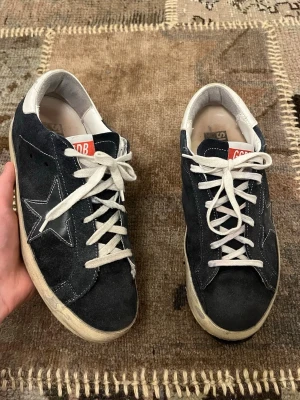 Mocka Golden Goose Superstar  - Snyggaste golden goose model och colorway i mocka. Är storlek 40 men jag har burit dem länge med 41 vilket passar. Vänstra sulans skick är rätt dåligt, men det är ingen fara att använda dem, se bilderna i annonsen. Skriv ifall du har fler frågor