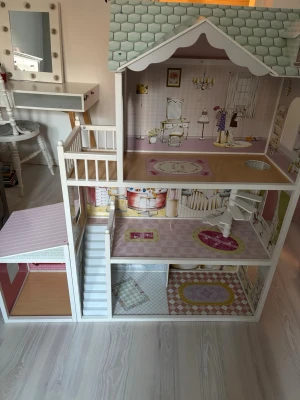 Jollyroom dockskåp trä flerfärgat - Säljer ett detaljerat dockskåp i trä med tre våningar, spiraltrappa och garage. Skåpet har pastellfärger som mintgrönt tak, rosa och vita väggar samt tryckta tapeter och mattor i varje rum. Perfekt för docklekar och inredning med egna möbler.                            38x84x123,5cm.                           Nypris:2000kr