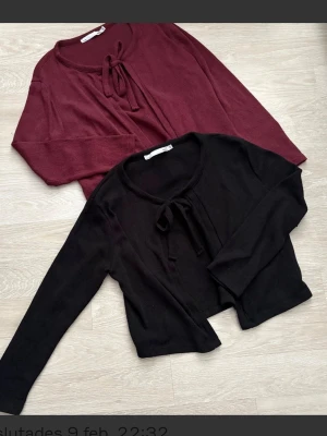 Lager 157 Två knytkoftor i vinrött och svart att S  - Två trendiga koftor med knytband framtill, en i vinrött och en i svart. Båda har rund halsringning och långa ärmar. Perfekta att slänga över en topp för en chill look. eller över en klänning. Från lager157