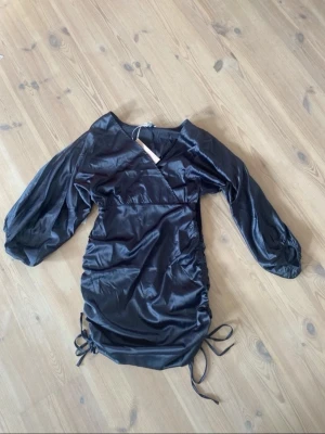 Svart omlottklänning med ballongärm - Jättefin! Det går att justera längden med snören på sidorna. 