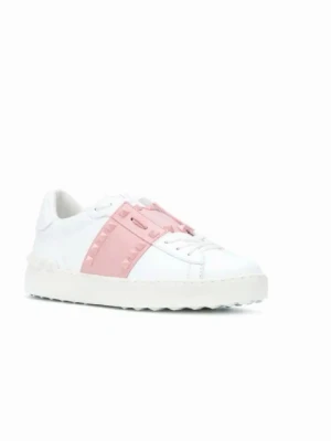 Valentino - Snygga vita sneakers från Valentino med en bred rosa rem över mitten, dekorerad med nitar. Skorna har klassisk låg profil, vita skosnören och en chunky sula. Tillverkade i slätt läder för en clean och modern look.