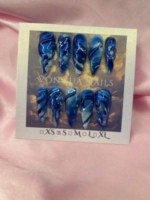 DeepSwim (S);Medium Stiletto - Snygga press-on naglar i blått, ljusblått och vitt med havs-mönster och 3D handmålade detaljer. Naglarna har en medium längd, stilettoformad design och en glansig finish. Perfekt för dig som vill ha en unik och trendig look.S: 15 mm, 11,5 mm, 12 mm, 11 mm, 9 mm 