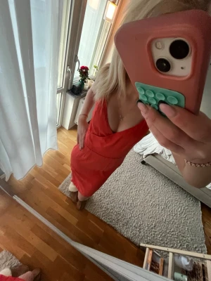 Röd omlottklänning med v-ringning - Säljer en röd omlottklänning med djup v-ringning och ärmlös design. Klänningen har en smickrande passform och går till knäna. Perfekt för dig som vill ha en enkel men snygg look. Materialet känns lätt och passar bra till varmare dagar.