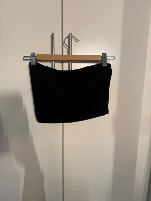 Svart och vit tubtopp i bomull - Två stilrena tubtoppar i svart och vitt, perfekta för sommaren. Båda är axelbandslösa och har en enkel, tight passform. Tillverkade i mjuk bomull som känns skön mot huden. Lätta att matcha med olika outfits och ett måste i garderoben.