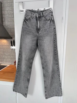 Grå raka jeans från H&M, stl XS - Snygga gråa jeans med hög midja och raka ben från H&M. Materialet är denim i bomull med en tvättad look som ger vintagekänsla. Använda max 5 gånger.